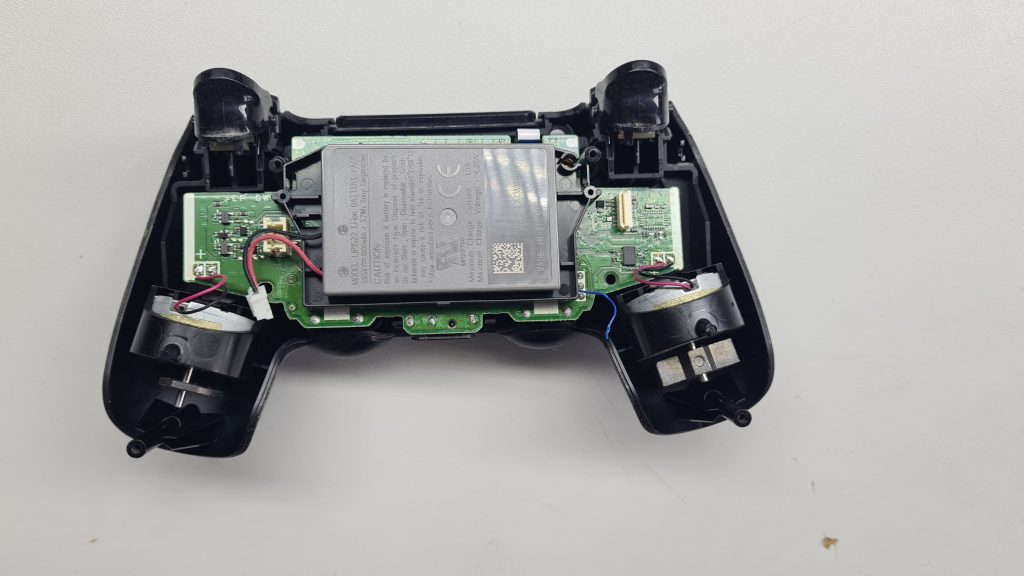 Mando DualShock PS4 abierto en mesa de taller GameSystems Leganés – Reparación mando PS4