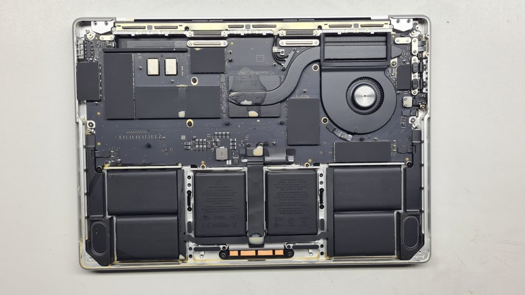 MacBook abierto con batería dañada a la vista – Cambio batería MacBook GameSystems Leganés