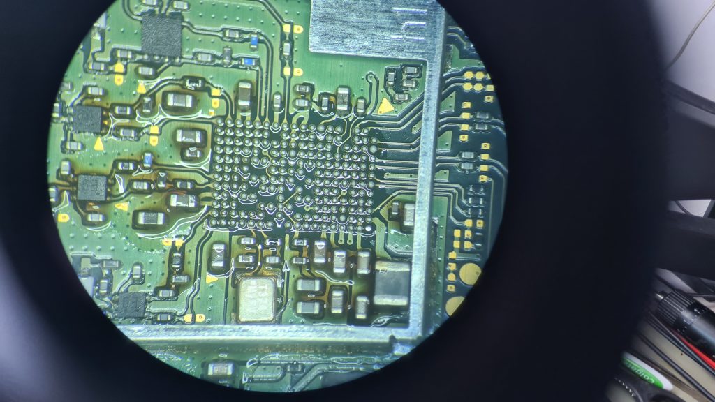 Detalle bajo microscopio del IC WiFi Bluetooth desoldado en la placa base de Nintendo Switch reparación IC WiFi Nintendo Switch — Fuencarral