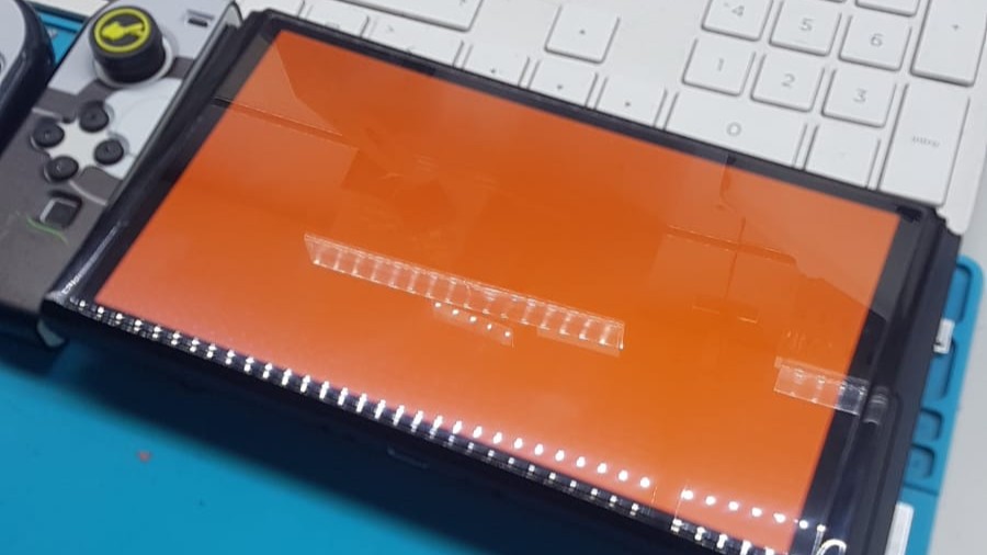 Microscopio mostrando pistas y componentes SMD de la placa base de Nintendo Switch antes de la reparación del IC WiFi
