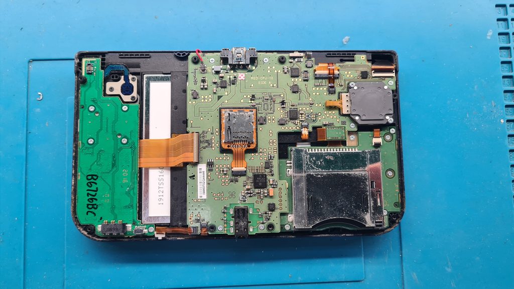 Placa base de una New 3DS XL abierta durante diagnóstico en GameSystems Leganés