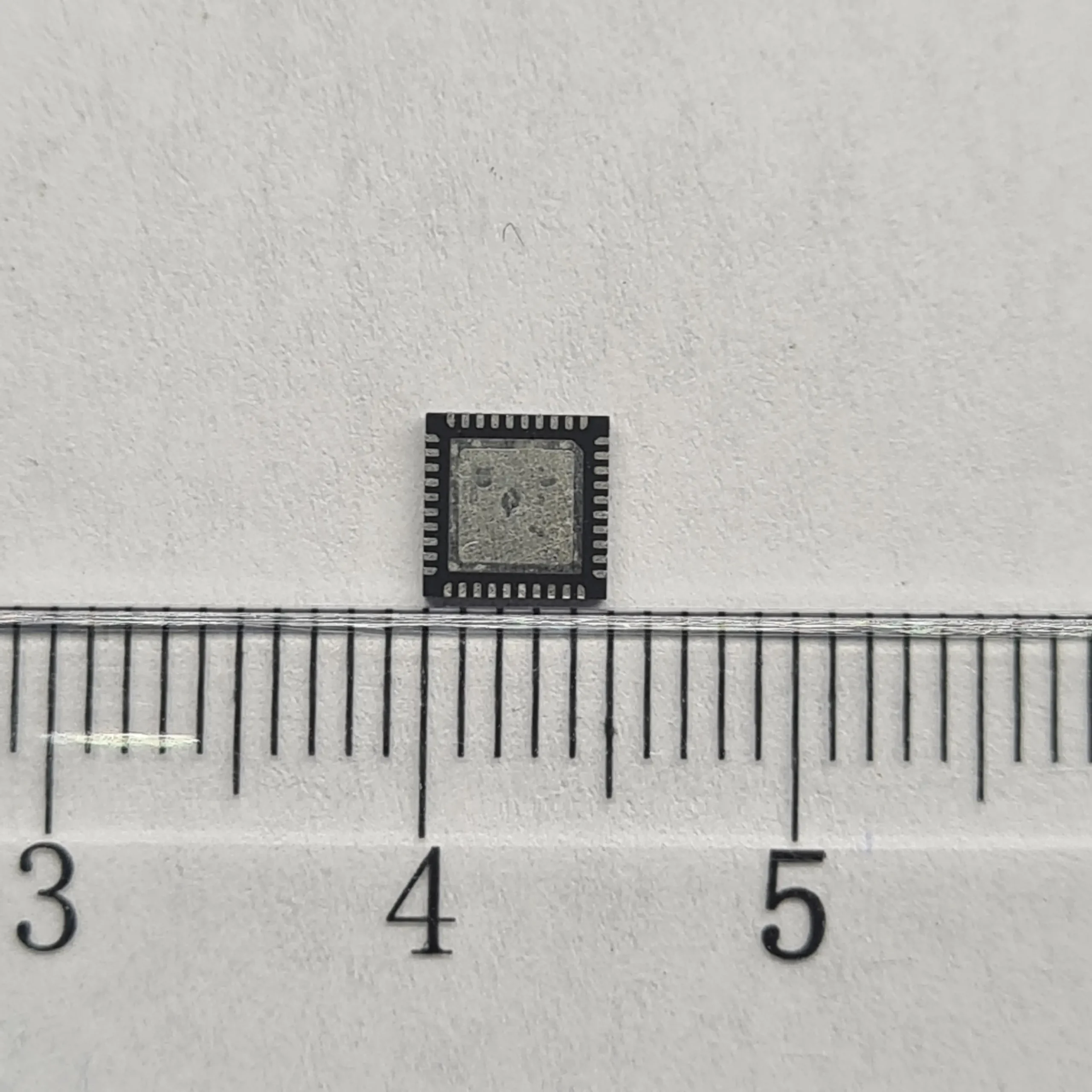 Chip M92T36 de la Nintendo Switch junto a una regla para ver su tamaño